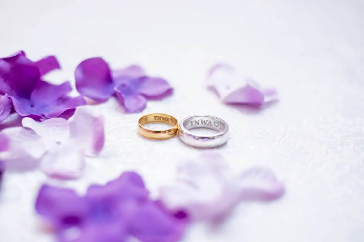 gold and silver wedding bands with mauve and violet flowers