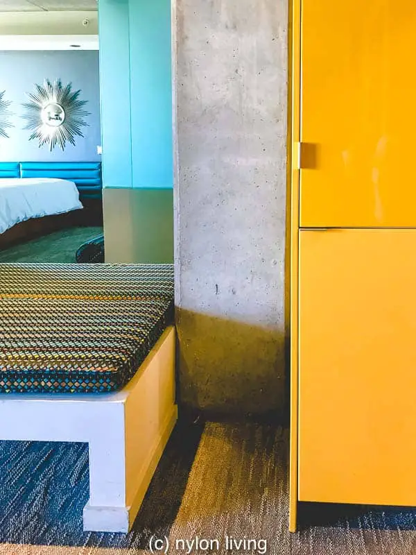 A bright yellow closet hides the hotel minibar 