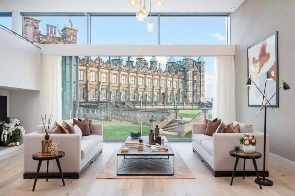 Double height ceilings and floor-to-ceiling windows maximises light flooding into the living room in these new build flats Edinburgh.