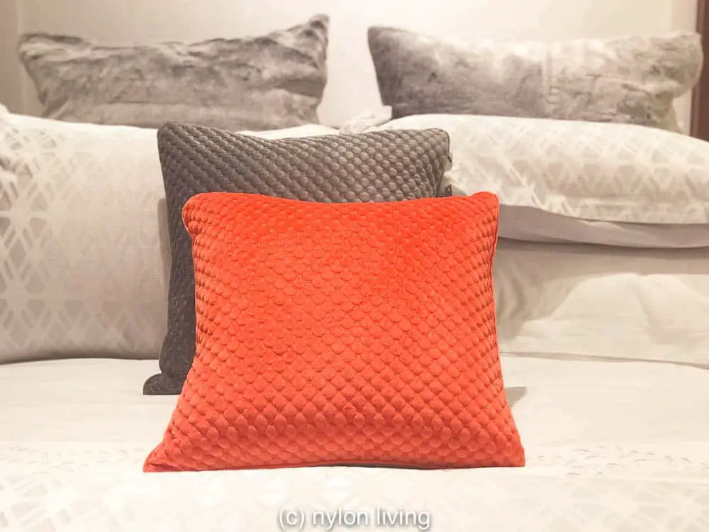 Create a coral and grey bedding look by simply accenting with coral colored throw pillows