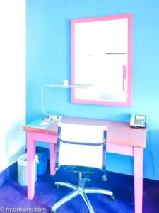 pink writing desk and mirror with a white chair