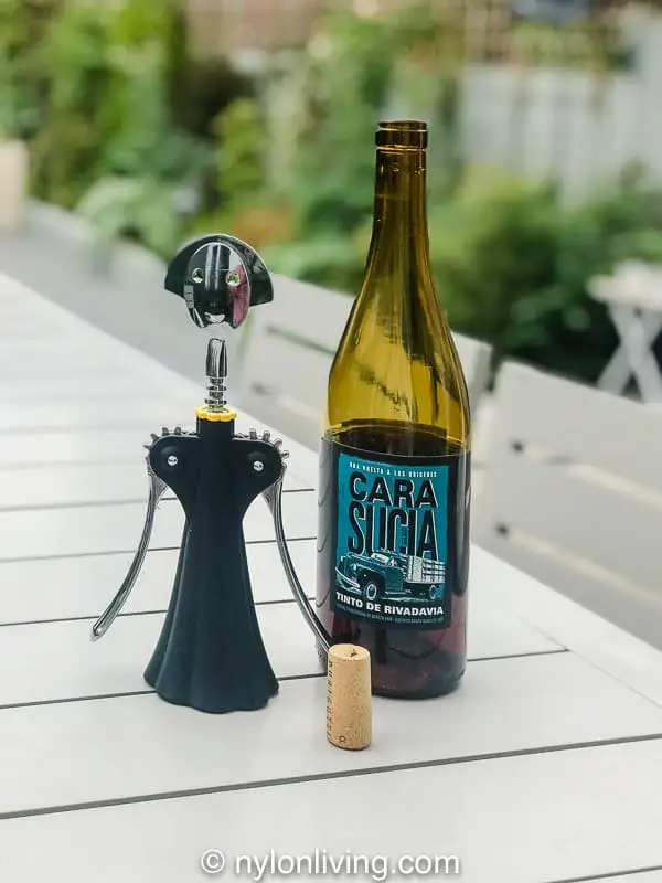 a cork, a bottle of red wine and a bottle opener
