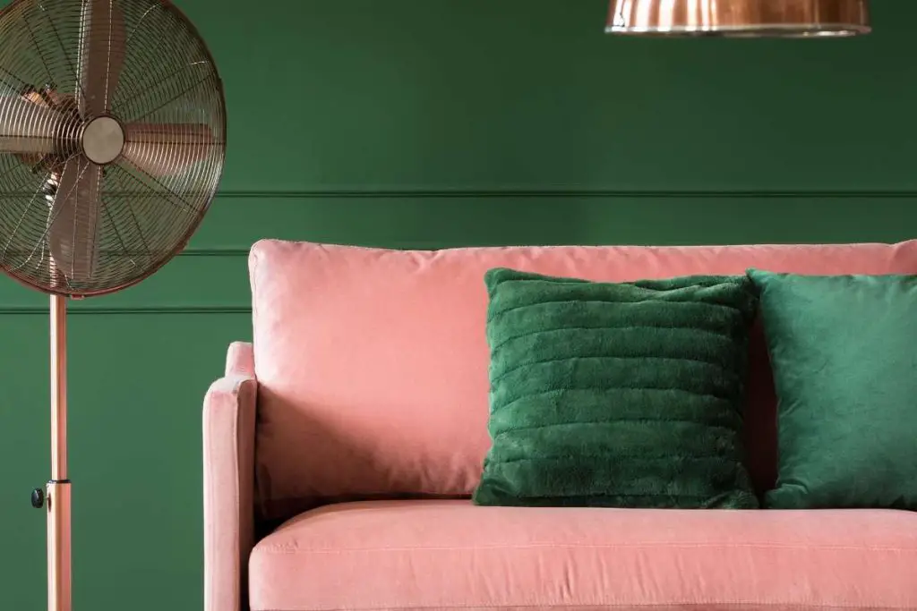 guava pink sofa with an emerald green cushion and wall color.