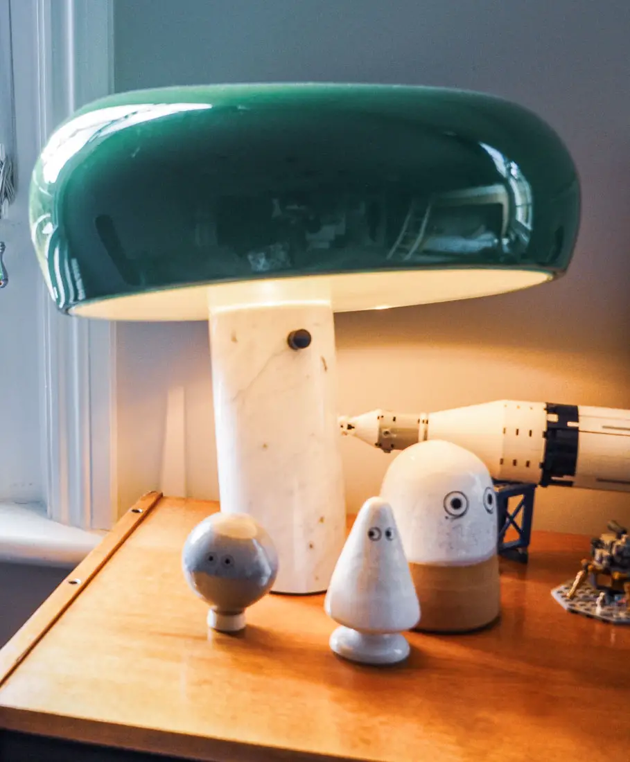 A snoopy lamp with an emerald green lampshade in a kid's room