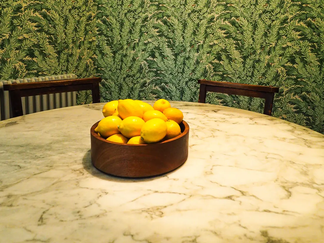 leafy wallpaper on a dining table with yellow lemons
